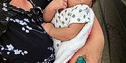 Vada is registered to the contest to win money with this photo: baby, sleeping, blanket, arms, person, hand, nail_polish, clothing, pattern, outdoor, car, sidewalk, infant, skin, face, peaceful, holding, pink, white, black