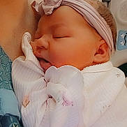 Samantha is registered to the contest to win money with this photo: baby, sleeping, headband, cuddling, infant, child, soft_clothing, indoor, closeup, person, peaceful, pink, pastel_colors, cute, portrait, newborn, family, tender, resting, cozy