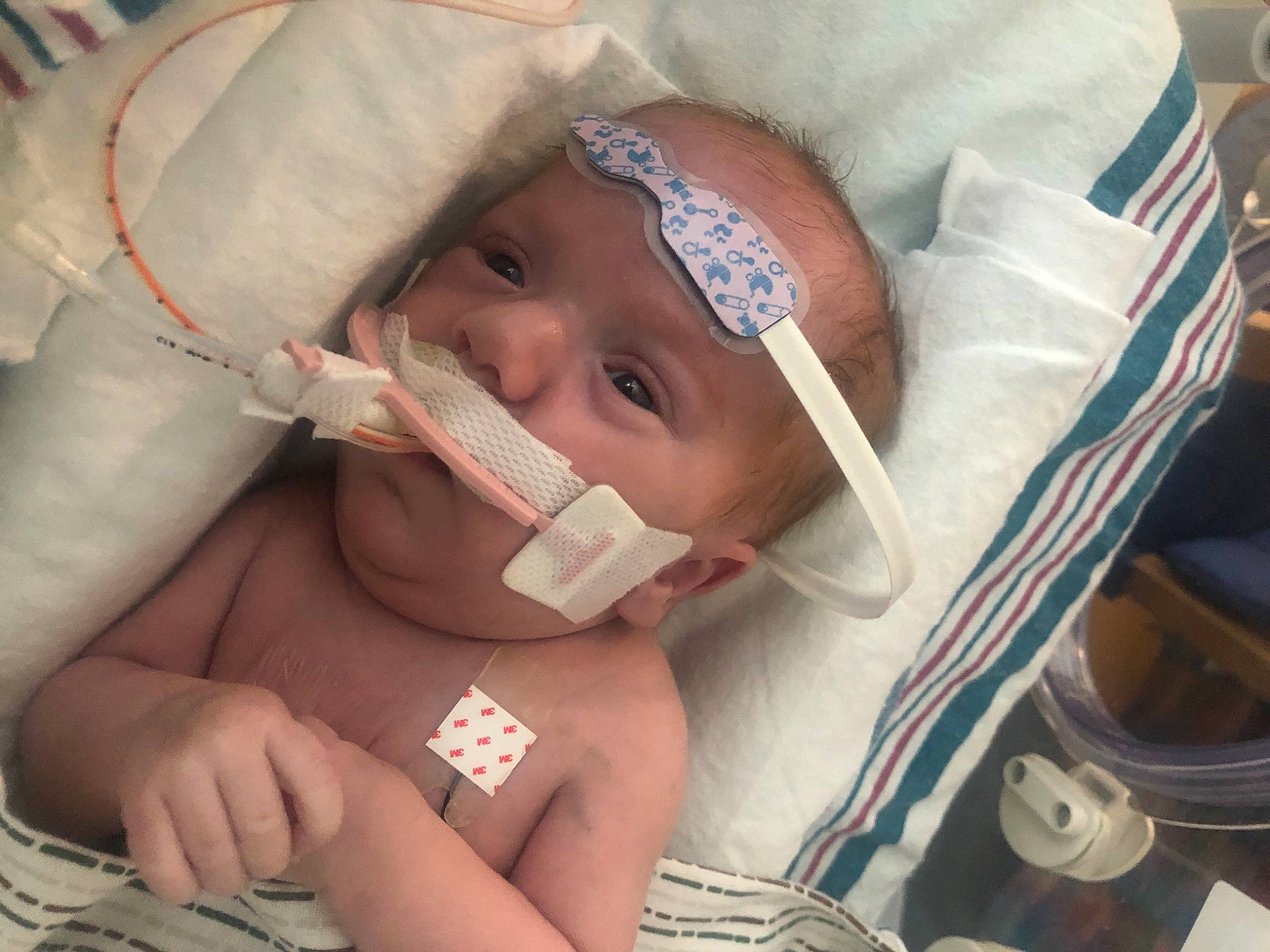 Roy is registered to the contest to win money with this photo: baby, cheek, chin, eye, eyebrow, eyelash, facial_expression, finger, forehead, hand, hat, head, headwear, health_care, jaw, lip, medical_equipment, mouth, neck, nose