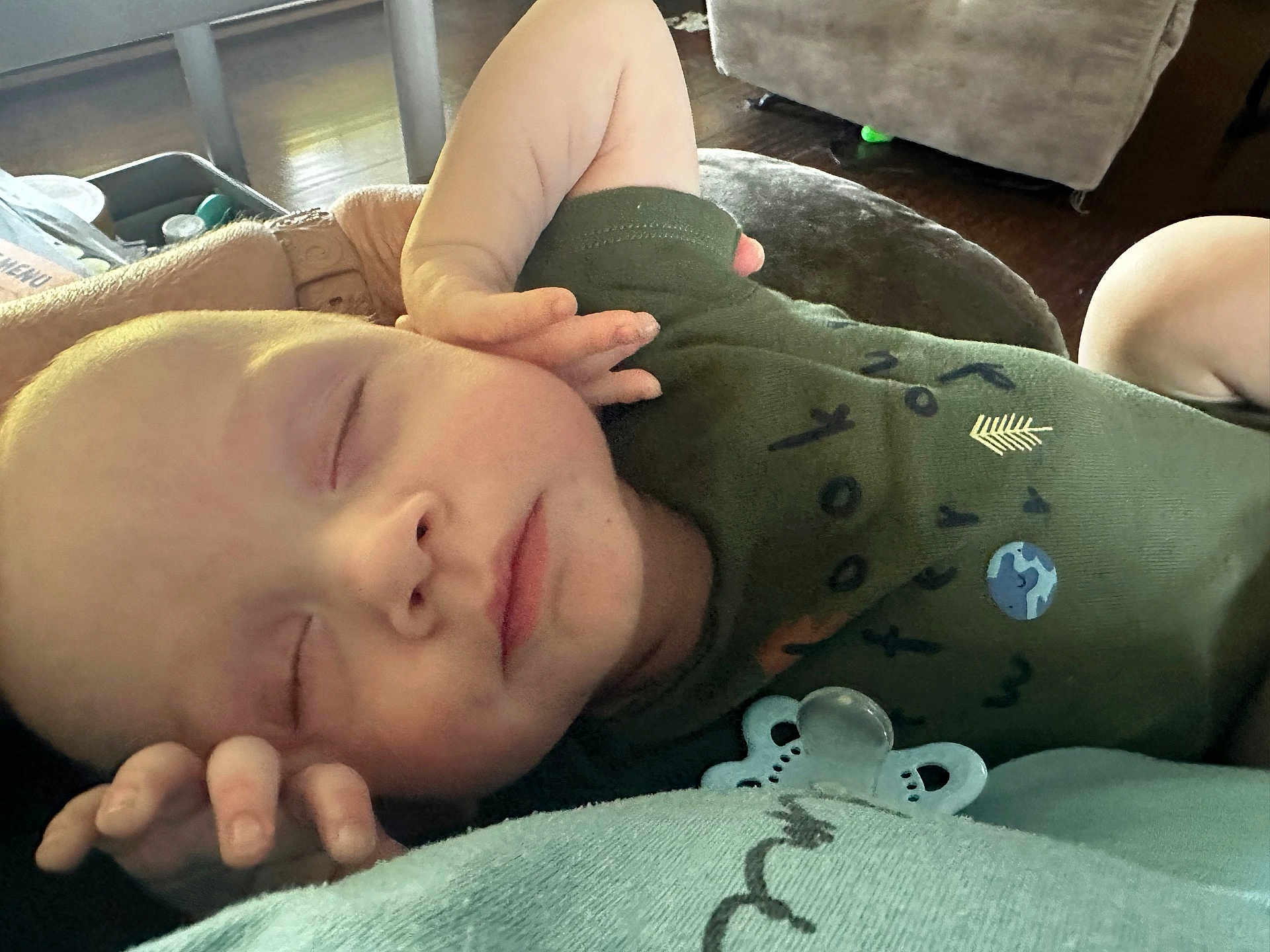 Conan is registered to the contest to win money with this photo: baby, child, closeup, clothing, cute, face, green, hand, human, indoors, infant, newborn, pacifier, peaceful, portrait, relaxing, resting, sleeping, soft_light, toddler