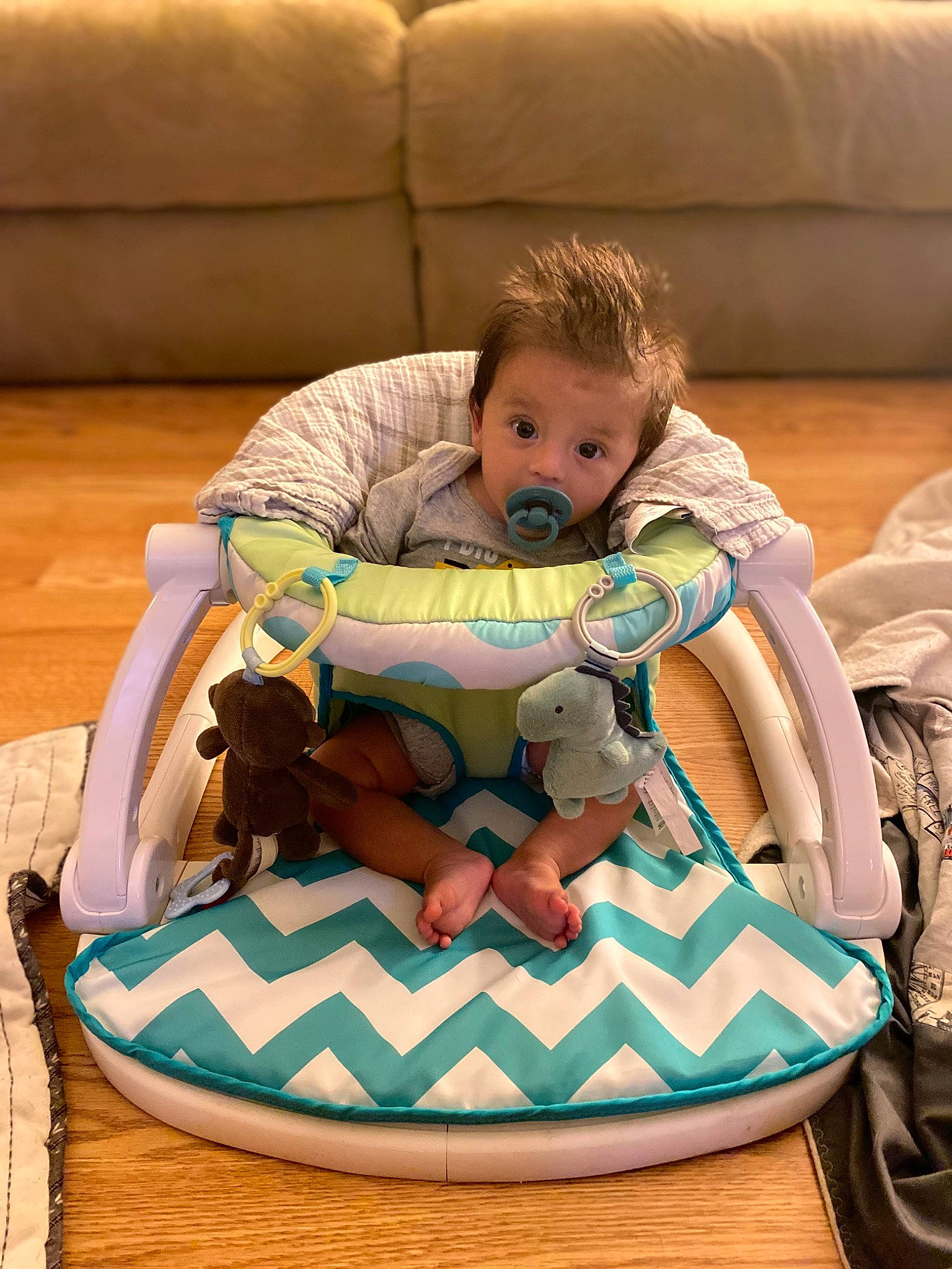 Colby is registered to the contest to win money with this photo: baby, baby_products, baby_toddler_clothing, bag, chair, child, comfort, couch, flooring, fun, lap, leisure, linens, pattern, person, room, sitting, stuffed_toy, surprise, thigh