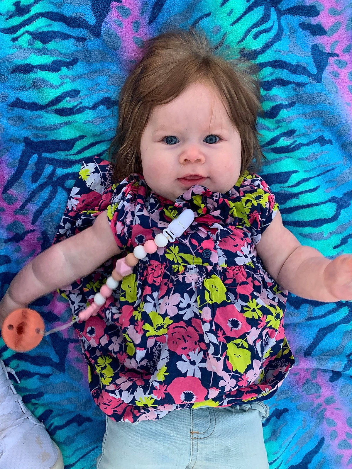 Lila is registered to the contest to win money with this photo: arm, baby_toddler_clothing, blue, cheek, clothing, eye, face, facial_expression, hairstyle, happy, head, human, iris, organ, people_in_nature, person, pink, purple, skin, sleeve