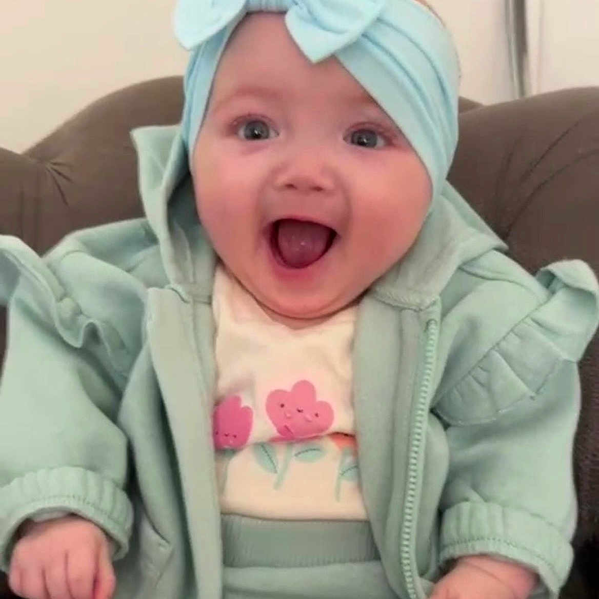 Romah Mae joined the competition — help win amazing prizes! apparel, baby, bow, child, clothing, cute, expression, face, hand, happy, headband, indoor, infant, jacket, joyful, pants, person, seat, sitting, smiling