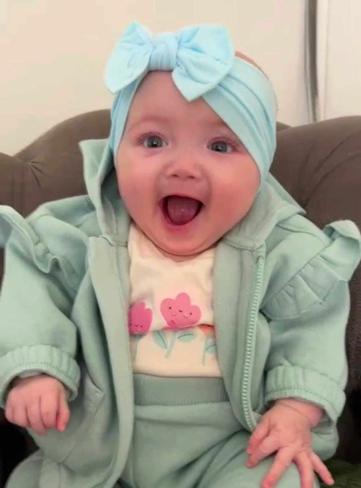 Romah Mae joined the competition — help win amazing prizes! baby, child, headband, bow, happy, smiling, clothing, jacket, pants, sitting, indoor, person, cute, face, hand, apparel, joyful, infant, seat, expression