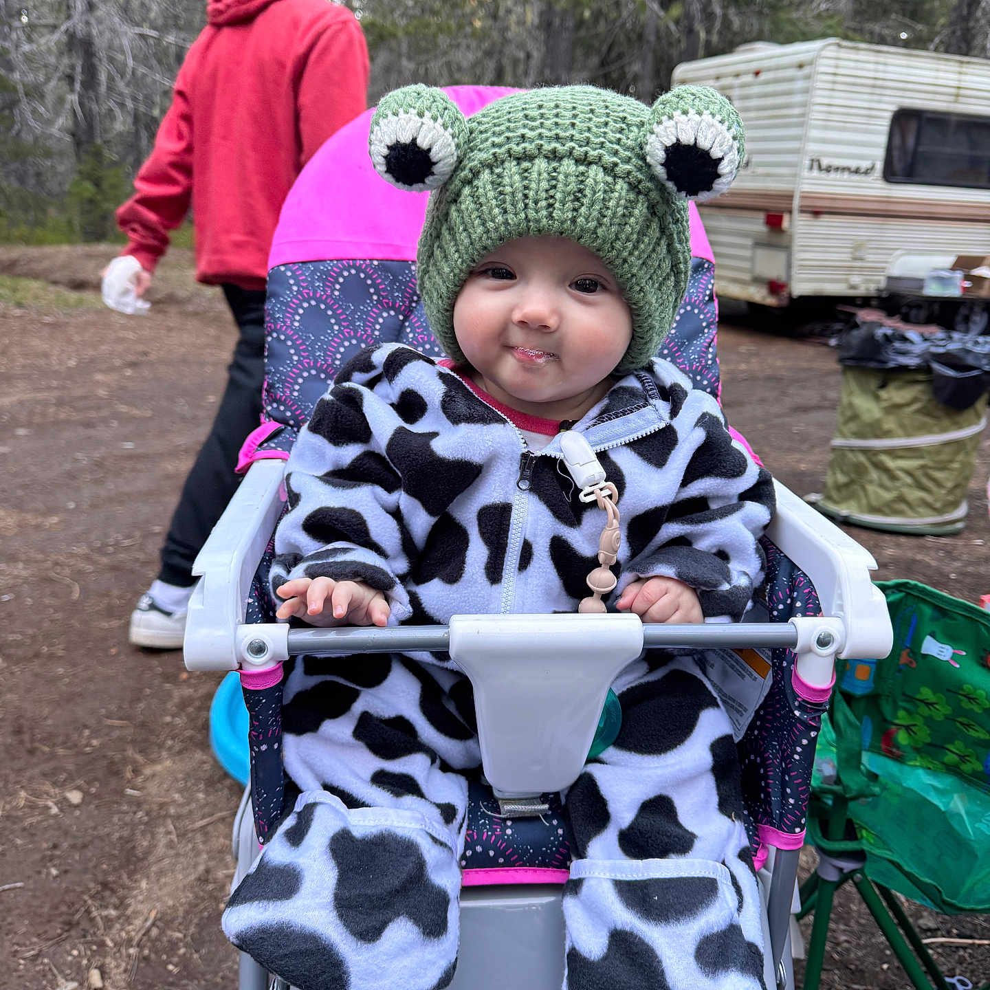Yuna joined the competition — help win amazing prizes! baby, camper, camping, child, cow_print, cute, forest, green_hat, happy, hat, jacket, knit_hat, nature, outdoor, person, seat, smile, stroller, toy_clip, walking