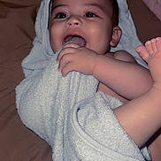 Xavier is registered to the contest to win money with this photo: baby, towel, infant, chewing, happy, playful, skin, face, hand, foot, bed, blanket, indoors, child, person, cute, smile, closeup, soft, relaxing