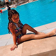 Mila Eshlesh a rejoint le concours — aidez-le/la à gagner de superbes lots ! child, girl, swimsuit, pool, water, sunny, outdoor, smile, wet_hair, palm_trees, vacation, relaxing, summer, blue_sky, sunshine, lounge_chairs, umbrella, holiday, playful, happy