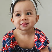 Eva joined the competition — help win amazing prizes! baby, child, crawling, headband, flower, patriotic, dress, stars, stripes, carpet, tongue_out, cute, smiling, indoor, person, infant, portrait, happy, young_child, neutral_background