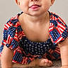 Eva joined the competition — help win amazing prizes! baby, child, girl, crawling, tongue_out, headband, patriotic_clothing, american_flag, carpet, indoor, cute, smiling, playful, flowers, cartoon_flowers, colorful, portrait, young_child, happy, soft_lighting