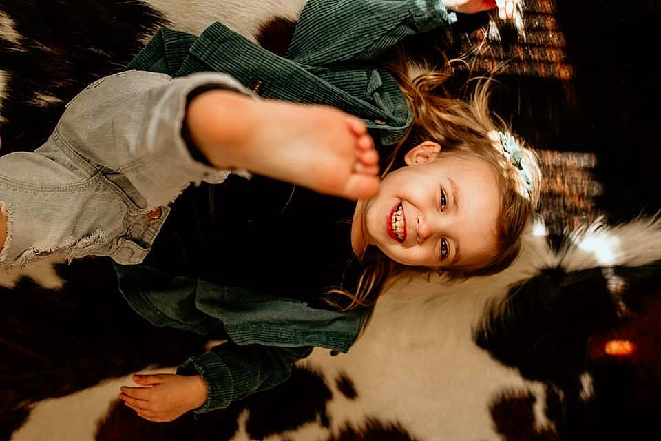Winsley Kate is registered to the contest to win money with this photo: child, denim, event, eye, face, flash_photography, fun, fur, gesture, grass, happy, head, human_body, interaction, joy, person, sitting, smile, toddler, tree