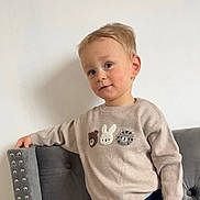 Vittorio participe au concours pour gagner de l'argent avec cette photo : toddler, child, sweater, animal_faces, beige, gray_chair, studs, indoor, portrait, casual_pose, curious_look, cute, young_child, short_hair, wall, fashion, clothing, person, smile, cute_expression