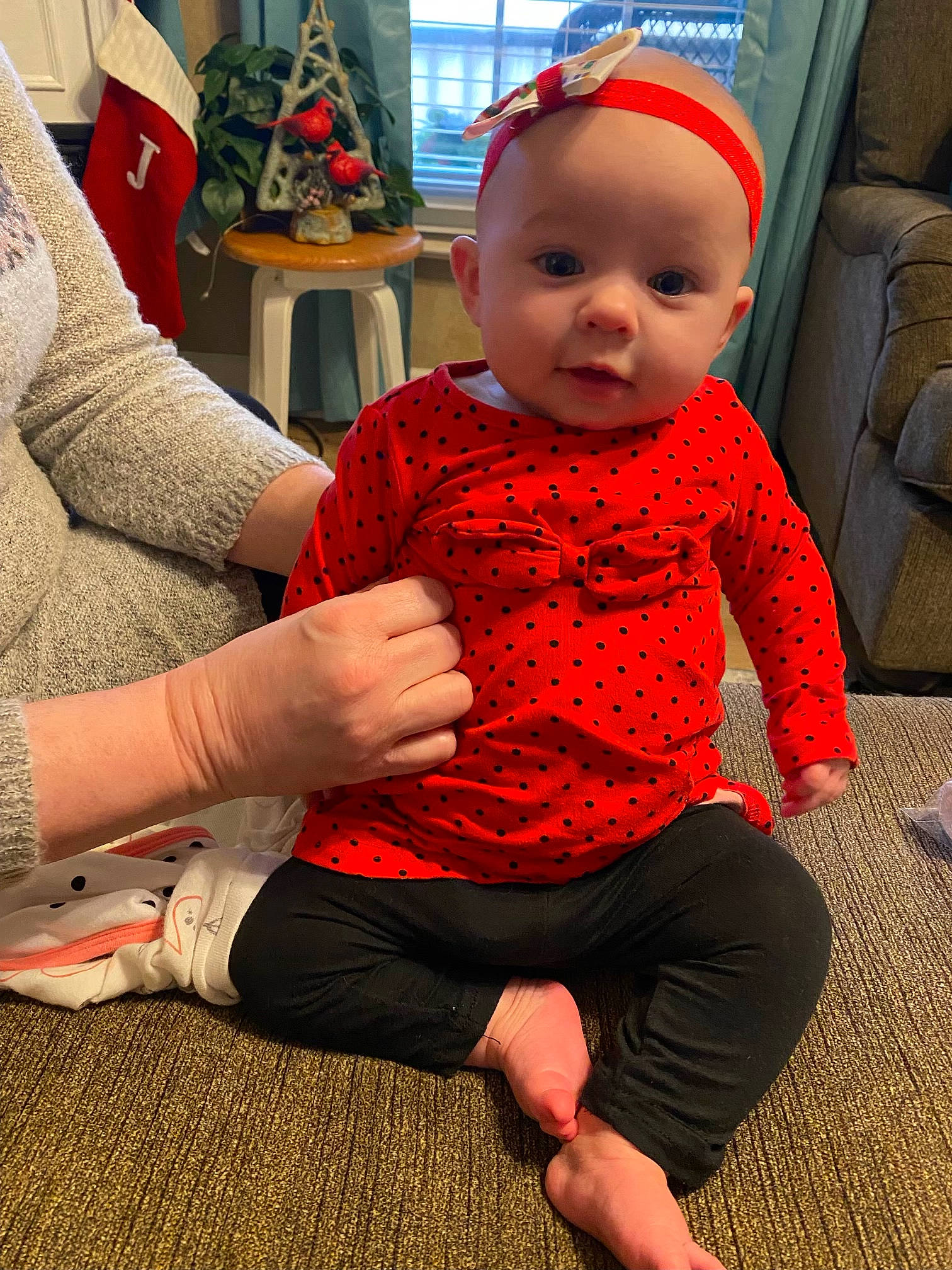 Zarah is registered to the contest to win money with this photo: baby, baby_toddler_clothing, child, comfort, event, finger, flooring, fun, happy, human_body, human_leg, knee, person, red, skin, sleeve, smile, sock, standing, thigh