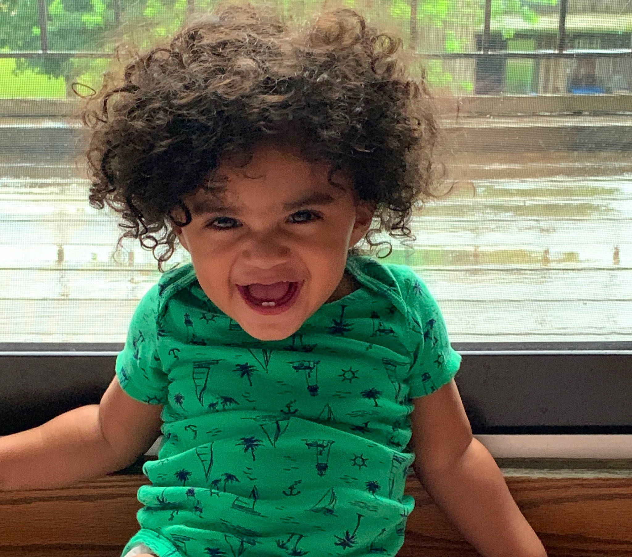 Leo is registered to the contest to win money with this photo: arm, cheek, child, chin, cool, face, facial_expression, green, hair, hairstyle, hand, happy, head, human, joy, nose, person, play, shoulder, smile