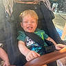 Thomas joined the competition — help win amazing prizes! toddler, child, stroller, smile, happy, outdoor, sunlight, casual, clothing, seatbelt, window, reflection, hand, face, hair, green_shirt, daylight, baby, sitting, playful