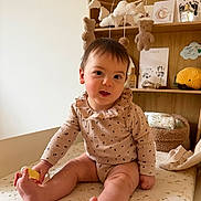 Malou a rejoint le concours — aidez-le/la à gagner de superbes lots ! baby, infant, child, nursery, mobile, stuffed_toys, teddy_bear, changing_table, bookshelf, wooden_shelf, onesie, sitting, toes, diaper, toy, portrait, indoor, cozy, smile, handprint_card