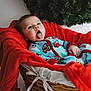 baby, child, tongue_out, pajamas, basket, blanket, red_blanket, wreath, holiday, christmas, cozy, cute, infant, portrait, indoor, smiling, funny_face, playful, clothing, decor
