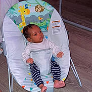 Javere is registered to the contest to win money with this photo: baby, infant, child, baby_rocker, striped_pants, bare_feet, indoor, wooden_floor, animal_print, giraffe, toucan, sloth, baby_clothing, seat_belt, baby_seat, toddler, cute, sitting, small_person, floor
