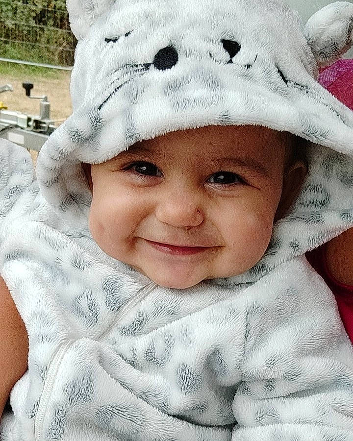 Mya a rejoint le concours — aidez-le/la à gagner de superbes lots ! baby_toddler_clothing, cap, cheek, chin, eyebrow, face, happy, headgear, headwear, joy, lip, nose, organ, outerwear, person, photograph, pink, skin, sleeve, smile