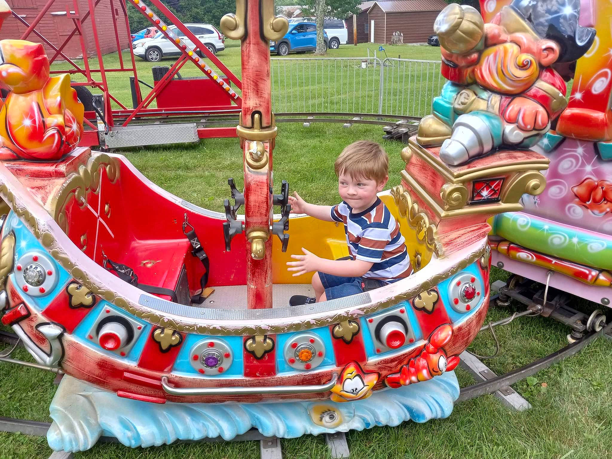 Ricky is registered to the contest to win money with this photo: amusement_ride, bumper, child, city, event, fun, games, grass, human_settlement, joy, leisure, mode_of_transport, motor_vehicle, outdoor_play_equipment, person, play, playground, recreation, toddler, toy