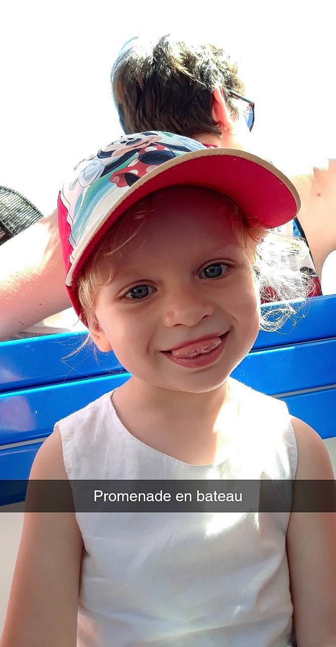 Julia participe au concours pour gagner de l'argent avec cette photo : baseball_cap, blue, cap, child, electric_blue, fun, happy, hat, headgear, headwear, joy, leisure, lip, person, personal_protective_equipment, pink, recreation, red, skin, smile