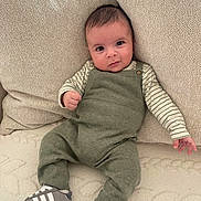 Aylan participe au concours pour gagner de l'argent avec cette photo : baby, infant, couch, cushion, pillow, green_overall, striped_shirt, sneakers, shoe, face, eyes, smile, knit_texture, cozy, indoors, portrait, hands, legs, blanket, adorable