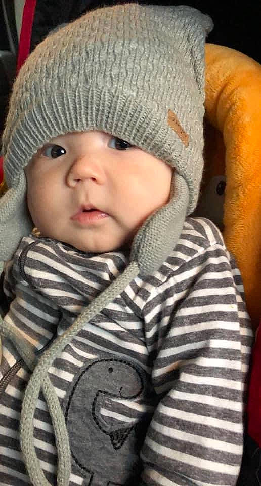 Ledger is registered to the contest to win money with this photo: baby, baby_toddler_clothing, cap, cheek, clothing, collar, comfort, cool, eye, face, head, headgear, headwear, knit_cap, lip, outerwear, person, skin, sleeve, textile