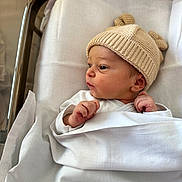 ève participe au concours pour gagner de l'argent avec cette photo : newborn, baby, infant, hospital, blanket, knit_hat, bassinet, bed, white_clothing, cute, face, skin, hand, sleepwear, portrait, indoors, resting, small_hands, side_profile, soft