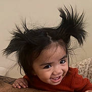 Saina is registered to the contest to win money with this photo: toddler, child, smile, happy, hair, wild_hair, pigtails, face, eyes, teeth, sweater, red_clothing, indoor, person, closeup, cute, joyful, playful, expression, portrait