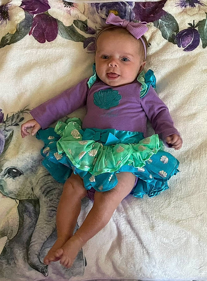 Claire joined the competition — help win amazing prizes! baby, baby_products, baby_toddler_clothing, carnivore, child, dress, event, fashion_accessory, happy, magenta, pattern, person, petal, pink, purple, ruffle, sitting, skin, sleeve, terrestrial_animal