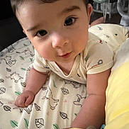 Kyle is registered to the contest to win money with this photo: arms, baby, blanket, child, close_up, cute, eyes, face, head, indoors, infant, lying_down, onesie, patterned_blanket, portrait, skin, smile, soft_light, toddler, young_child