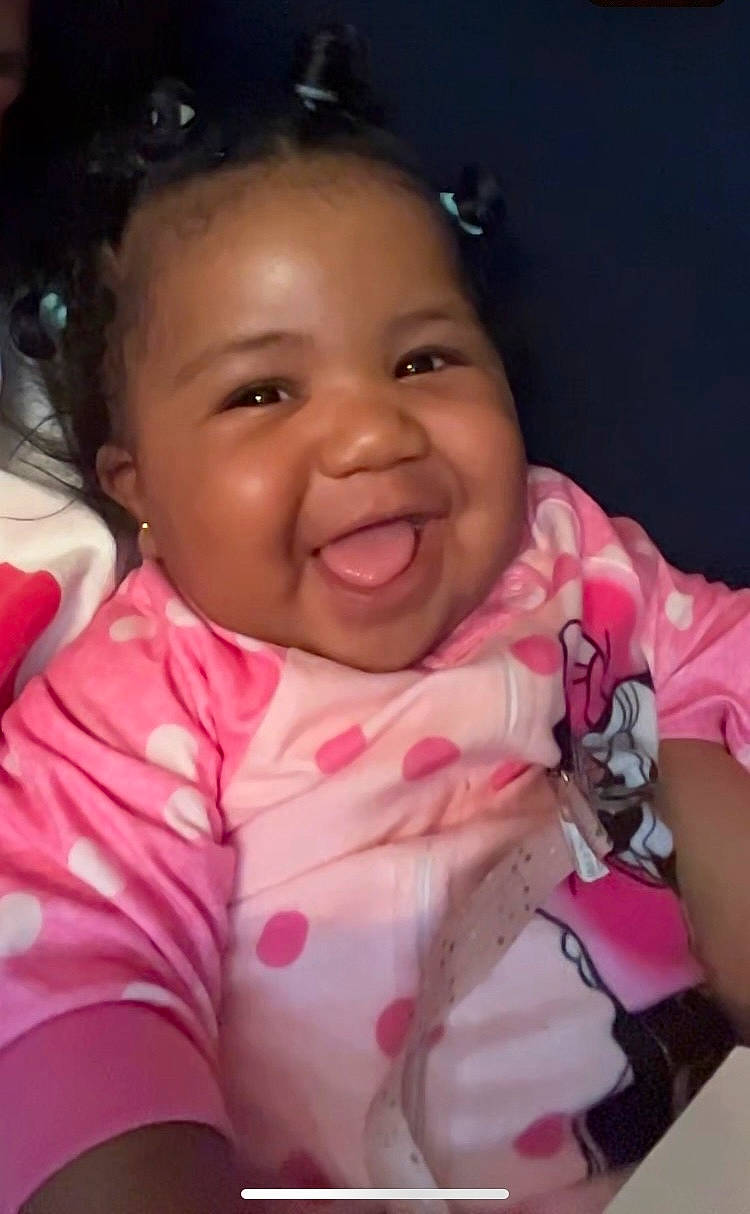 Destiny is registered to the contest to win money with this photo: arm, baby_toddler_clothing, cheek, chin, comfort, ear, eyebrow, finger, gesture, happy, human_body, iris, joy, lip, mouth, neck, nose, person, pink, skin