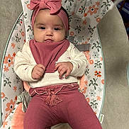 Sofia is registered to the contest to win money with this photo: baby, infant, headband, bow, bib, onesie, leggings, bouncer_seat, floral_pattern, drool, hands, cheeks, eyes, smile, cushion, pastel_colors, clothing, portrait, indoor, safety_strap