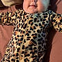 Ariel joined the competition — help win amazing prizes! baby, infant, smile, leopard_print, onesie, blanket, bed, child, face, cute, happy, lying_down, indoors, cozy, soft, young_child, person, apparel, sleepwear, resting