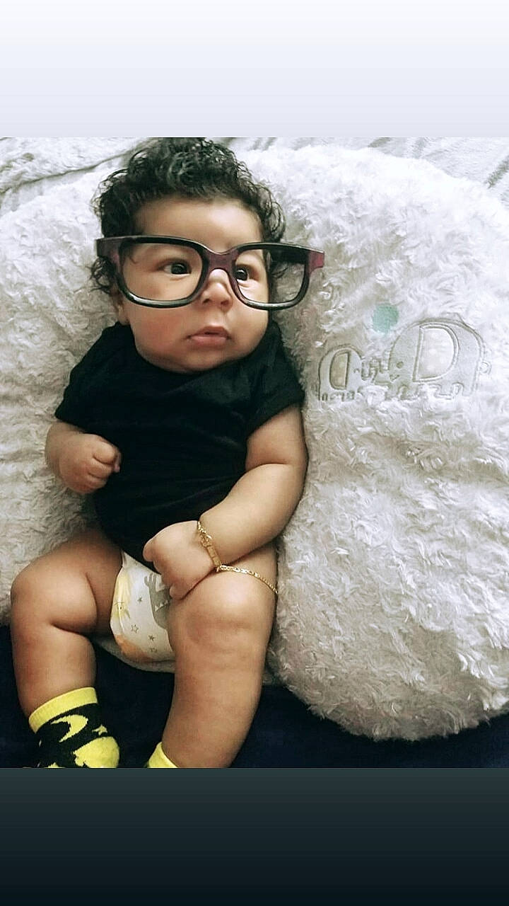 Chayse is registered to the contest to win money with this photo: arm, baby, black_hair, cheek, child, child_model, cool, eye, eyewear, face, glasses, leg, nose, outerwear, person, photo_shoot, photography, skin, smile, toddler