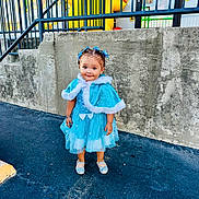 Amariah is registered to the contest to win money with this photo: asphalt, blue_dress, cape, child, concrete_wall, cute, daylight, fashion, hair_bows, inflatable, outdoor, person, portrait, railing, shoes, smiling, standing, toddler, urban, yellow_inflatable