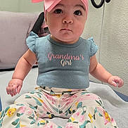 Violet joined the competition — help win amazing prizes! baby, child, girl, pink_bow, headband, shirt, floral_pants, sitting, indoors, curious_expression, cushion, foot, hand, face, portrait, cute, clothing, infant, young_child, apparel