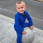 Ethan a rejoint le concours — aidez-le/la à gagner de superbes lots ! child, boy, blue_suit, bow_tie, smiling, sidewalk, cobblestone, stone_ball, urban, street, cars, casual, playful, fashion, outdoor, concrete, pavement, young, portrait, happy