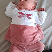 Lylou a rejoint le concours — aidez-le/la à gagner de superbes lots ! baby, sleeping, infant, pink_clothing, white_clothing, dragonfly, bed, blanket, socks, soft_fabric, peaceful, cute, child, newborn, person, indoors, resting, small_hands, cozy, portrait
