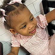 Legend Amor is registered to the contest to win money with this photo: child, toddler, girl, portrait, smiling, pink_outfit, hair_bows, curly_hair, earring, sitting, chair, indoor, tiled_wall, close_up, face, eyes, clothing, happy, photography, adorable