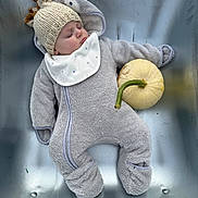 Oscar is registered to the contest to win money with this photo: baby, sleeping, knitted_hat, onesie, pumpkin, metallic_surface, infant, cozy, cute, autumn, soft_clothing, peaceful, child, headwear, lying_down, small_pumpkin, baby_bib, warm_clothing, indoor, portrait