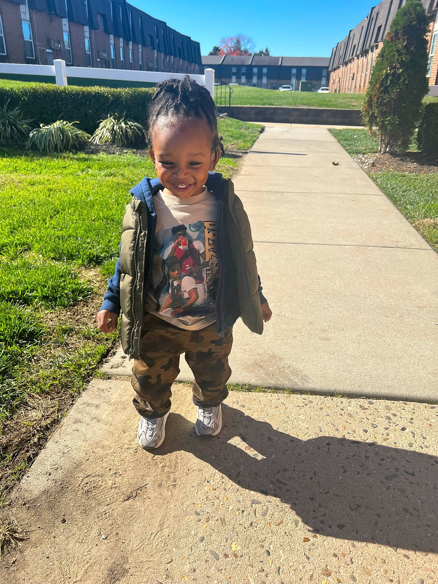 Demetrius is registered to the contest to win money with this photo: asphalt, baby_toddler_clothing, child, city, flooring, fun, grass, happy, joy, landscape, leisure, people_in_nature, person, plant, recreation, road_surface, sky, sleeve, soil, toddler