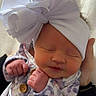 baby, newborn, infant, sleeping, headband, bow, floral_clothing, cute, peaceful, hand, fist, soft, portrait, child, person, indoor, human, adorable, closeup, resting