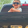 Jayden is registered to the contest to win money with this photo: black, car, child, cool, cute, daylight, hands, happy, nature, outdoor, person, portrait, reflection, shirt, smile, sunglasses, toddler, tree, truck, vehicle