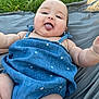 baby, infant, child, tongue_out, blue_dress, blanket, grass, outdoors, smiling, chubby_cheeks, portrait, candid, arm, leg, head, face, summer, picnic, fabric, playtime