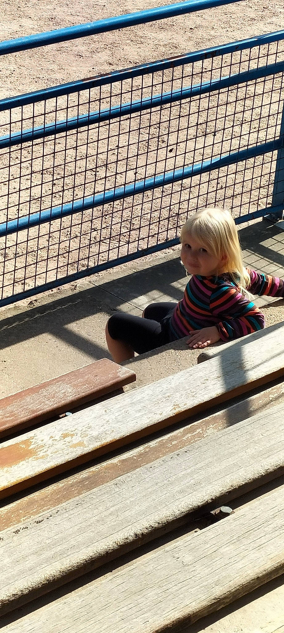 Lilou participe au concours pour gagner de l'argent avec cette photo : baby_toddler_clothing, chain_link_fencing, child, composite_material, electric_blue, fence, flooring, fun, hardwood, leisure, mesh, pattern, person, play, shade, shadow, sitting, tints_and_shades, toddler, wire_fencing