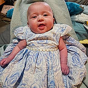 Maeve joined the competition — help win amazing prizes! baby, infant, smiling, dress, floral_dress, towel, blanket, portrait, close_up, chubby_cheeks, hands, fabric, cute, adorable, newborn, lying_down, home_interior, soft_texture, blue, beaded_belt