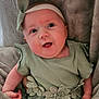 baby, infant, green_dress, headband, flower_decoration, blanket, soft_texture, cute, portrait, child, young, smiling, face, eyes, hand, clothing, lying_down, indoor, closeup, adorable