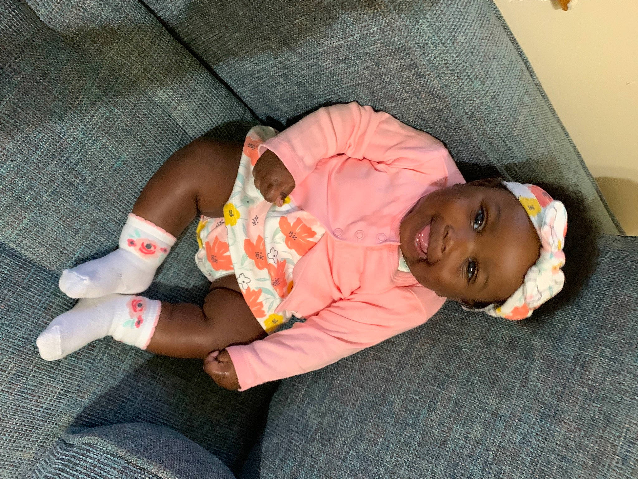 Ariya is registered to the contest to win money with this photo: baby, baby_products, baby_toddler_clothing, child, comfort, eye, finger, flooring, grass, headwear, human_leg, joy, knee, lap, leg, linens, person, sitting, skin, sock