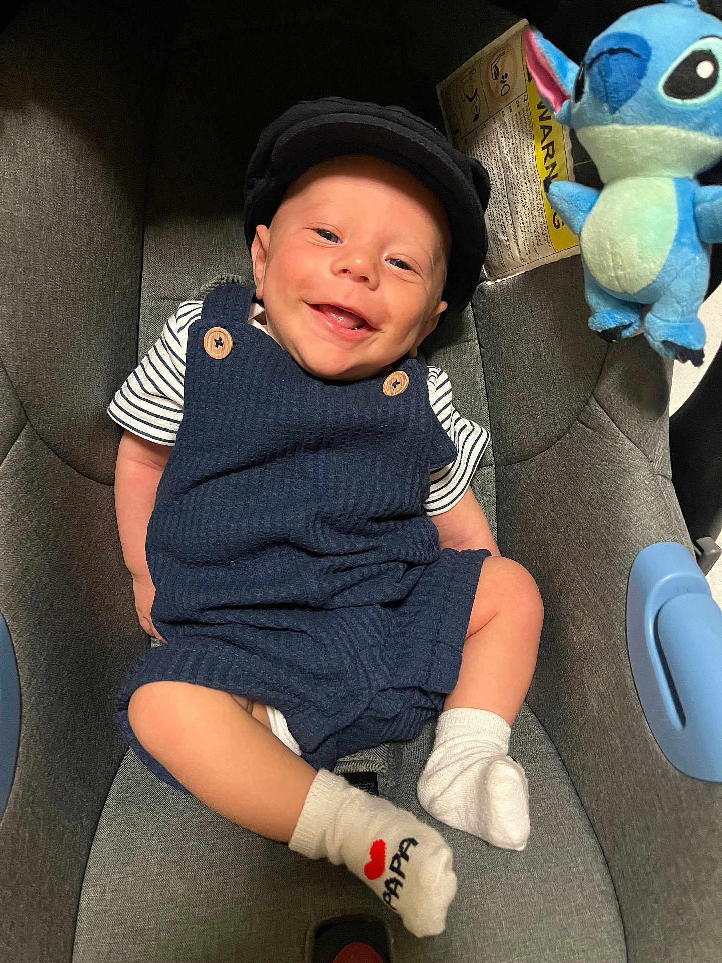 Naëllio a rejoint le concours — aidez-le/la à gagner de superbes lots ! baby, smile, romper, cap, socks, car_seat, plush_toy, stitch, child, happy, infant, cute, indoor, clothing, person, seat, toy, fabric, comfort, playful