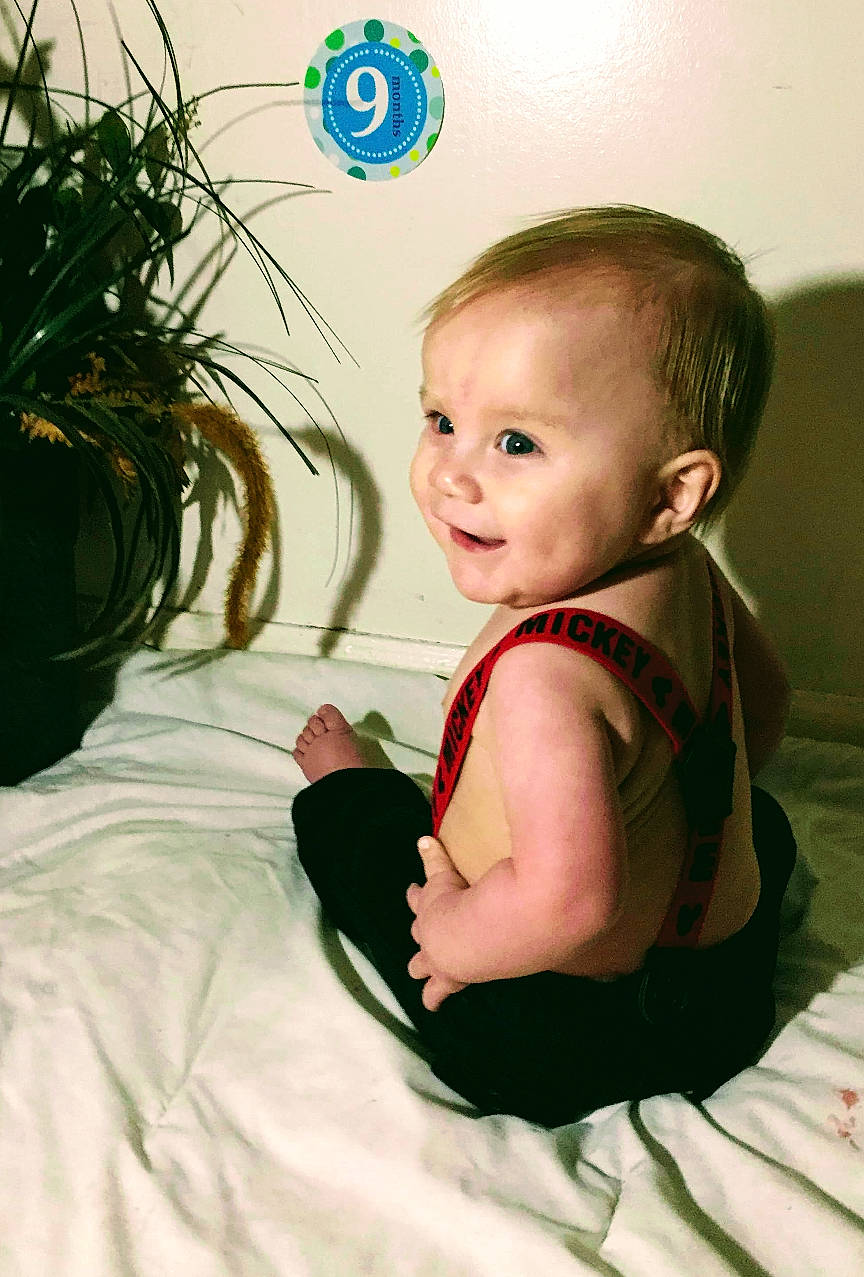 Paxtyn is registered to the contest to win money with this photo: arm, baby, baby_products, baby_toddler_clothing, cheek, child, ear, electronic_device, eye, face, green, head, headwear, iris, nose, person, product, sitting, skin, smile